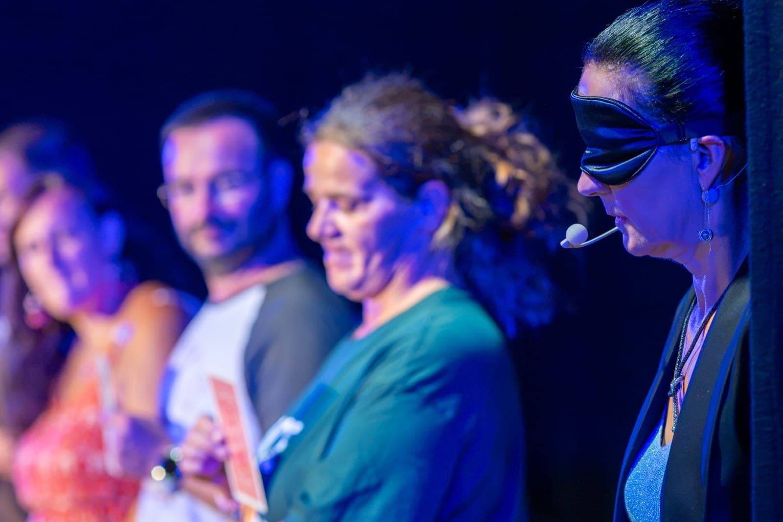 Karine de profil, les yeux bandés, concentrée, dans une lumière bleue