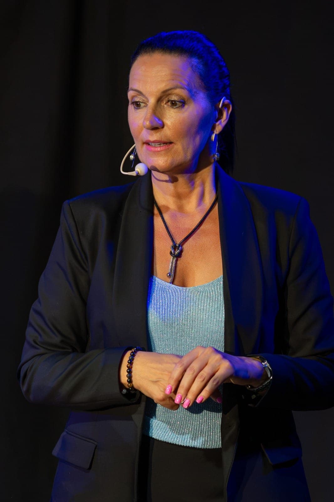 Portrait de Karine sur scène, éclairée par une lumière bleue